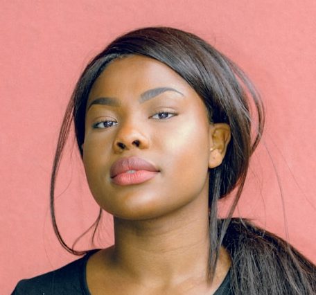 woman wearing black shirt standing in front of red wall