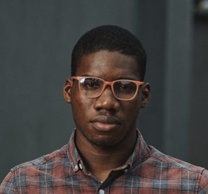 man in blue red and white plaid dress shirt holding yellow plastic bowl
